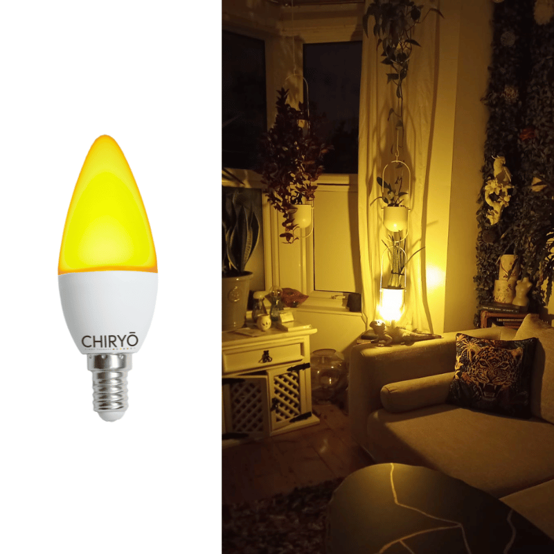Sunset amber light bulb candle no blue light e14 healthy lighting CHIRYO LIGHT THERA (3) sunset amber light bulb sleep candle e14 in a bedside lamp casting warm amber light beside a sofa with decorative cushions and plants in a low-stimulation evening setting