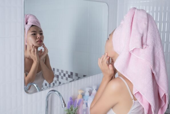 Ointments and Skincare wisdom article blog how to maximise the benefits of LED Light Therapy CHIRYO Light Therapy washing face looking into bathroom mirror