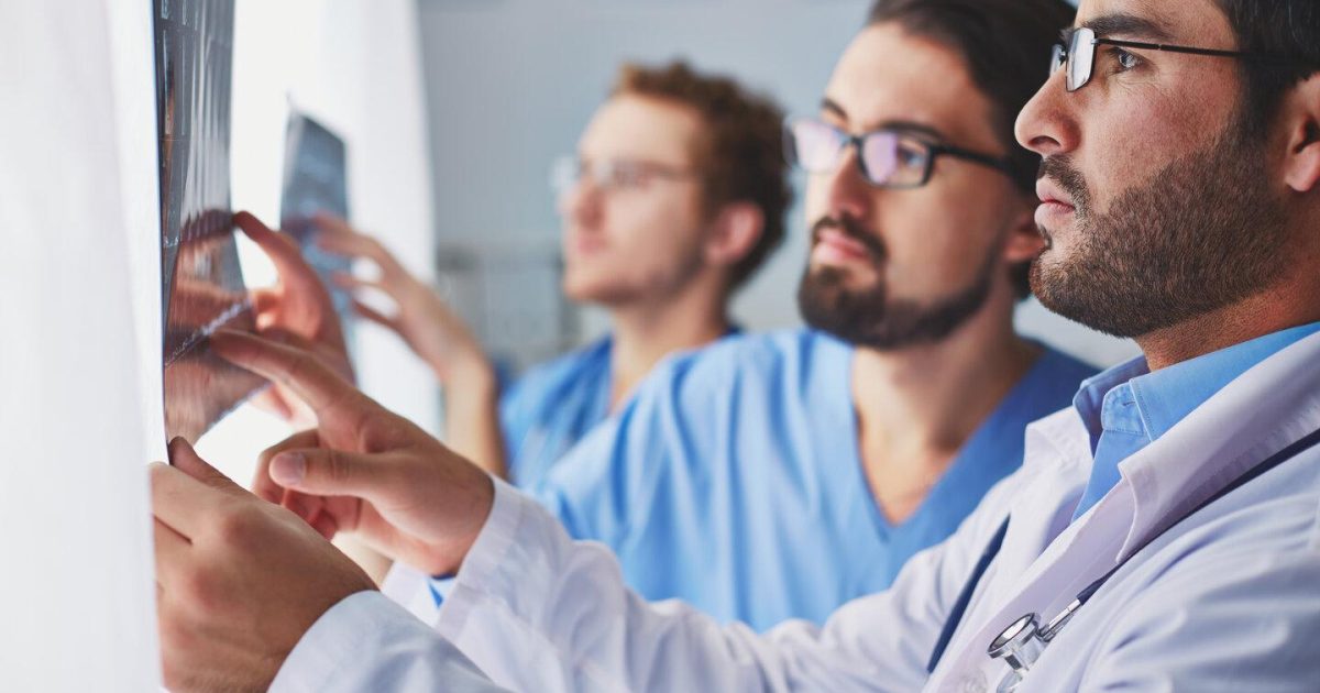 Showing x-ray pressfoto Portrait of young male doctors looking at x-ray